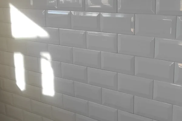 Bijele zidne subway pločice s dekorativnom staklenom bordurom visokog sjaja
